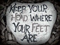 painted stone with keep your head where your feet are quote