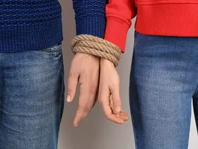 Couple with tied together hands depicting sex and love addiction