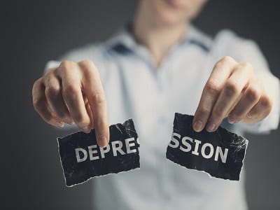 person holding torn label with the word depression depicting effective treatment