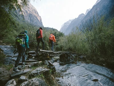 hikers crossing a river outdoors